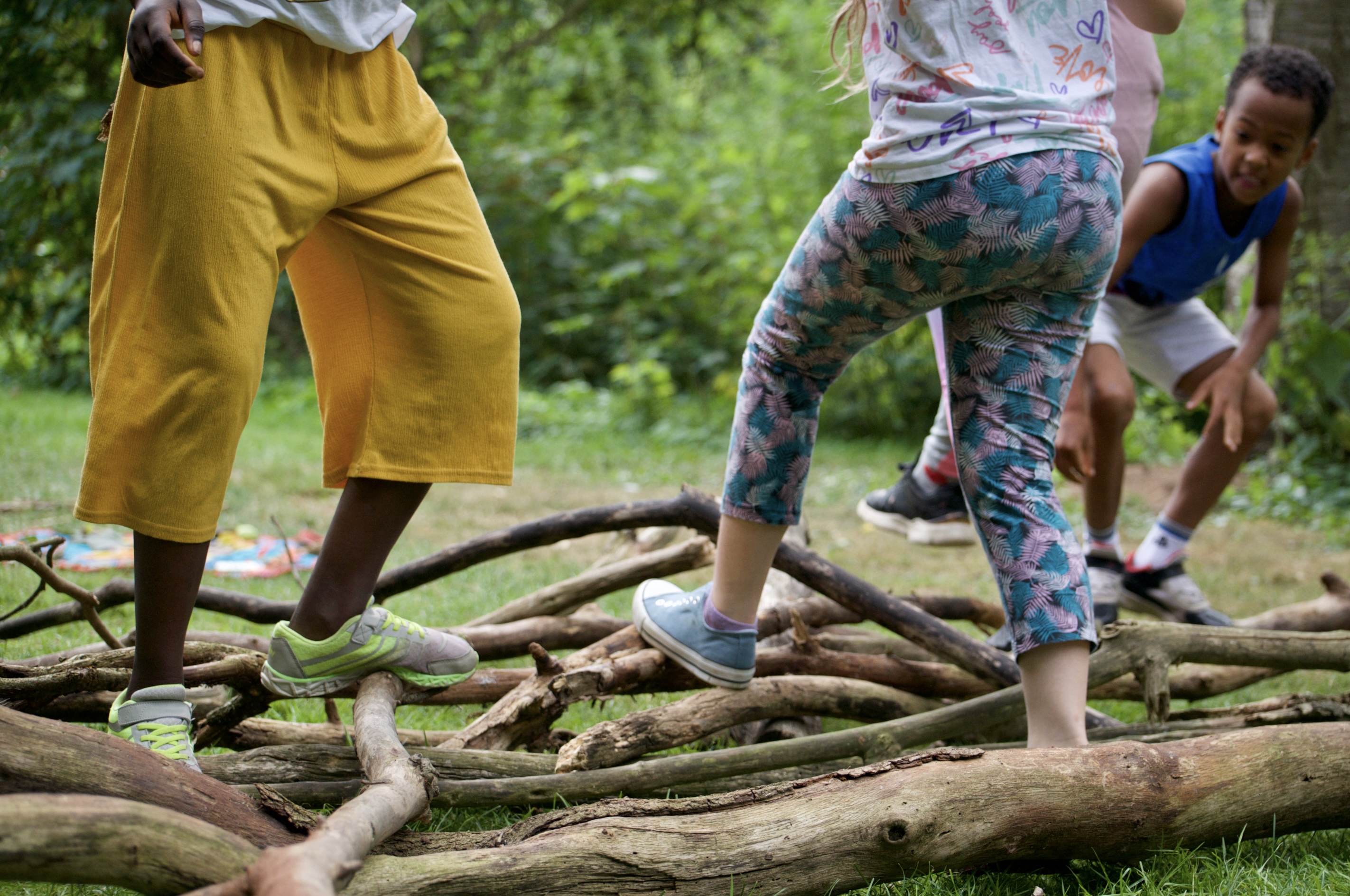 Kinder balancieren über Äste und Stämme im Grünen